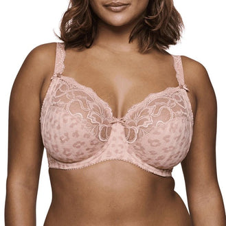 A close-up of a model wearing a light pink leopard-print lace bra with underwire and adjustable shoulder straps, shown against a plain white background.